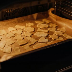 A tray of assorted shaped cookies baking in an oven, perfect for festive treats.