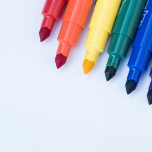 Vibrant rainbow-colored markers placed on a blank canvas, ready for creativity.