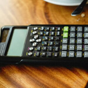 Detailed view of a scientific calculator placed on a wooden table surface.