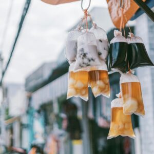 Plastic bags of drinks hanging in an urban street setting showcasing local street food culture.