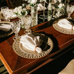 Luxurious table setup featuring ornate plates, crystal glassware, and floral decor.