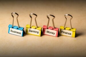 Close-up of binder clips with labels for business, banking, money, and finance concepts.