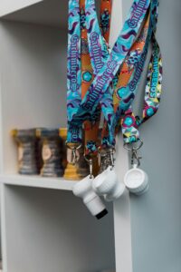Vibrant lanyards featuring skull designs hang beside shisha bowls in a modern setting.