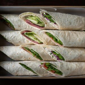 Appetizing wraps arranged in a box, showcasing fresh ingredients from a top view.