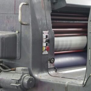 Detailed view of an industrial printing machine showcasing parts and rollers in action.