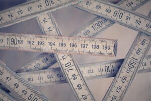 A collection of vintage folding rulers measuring in centimeters on a neutral background.