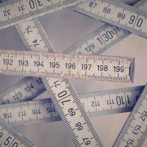 A collection of vintage folding rulers measuring in centimeters on a neutral background.