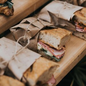 Delicious homemade sandwiches wrapped in rustic paper on a wooden table.