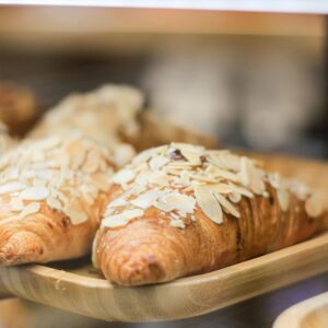 Close-up of delicious almond croissants on tray in a café bakery.