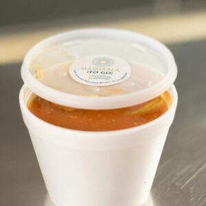 White to-go container with soup from Mashaal Restaurant in plastic cup.