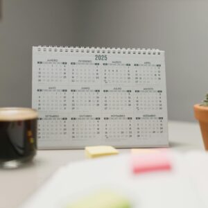 A 2025 desk calendar with coffee and succulent, ideal for planning and office decor.