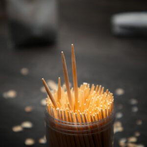 A detailed shot of toothpicks in a jar on a dark surface, ideal for kitchen or tabletop themes.