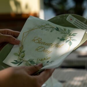 Elegant napkin with 'Beautiful Day' design on outdoor table, ideal for events.