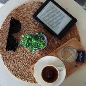 Top view of a cozy café table with an ebook, Turkish coffee, and succulent plant.