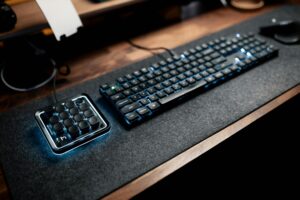 Ergonomic desk setup featuring a mechanical keyboard and macro pad with LED lighting.