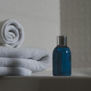Luxurious white towels and blue bottle create a tranquil spa atmosphere.