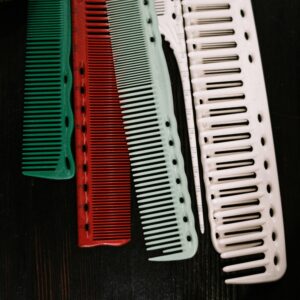 A set of colorful plastic combs arranged on a dark background.