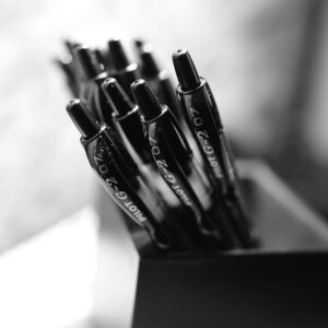 Black pens neatly arranged in a holder, captured in monochrome for a classic look.