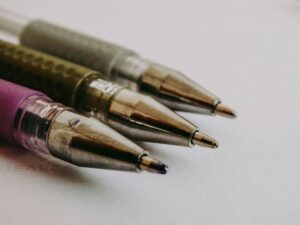 Macro photo showcasing the precision of three ballpoint pen tips in focus on paper.