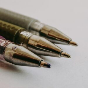 Macro photo showcasing the precision of three ballpoint pen tips in focus on paper.