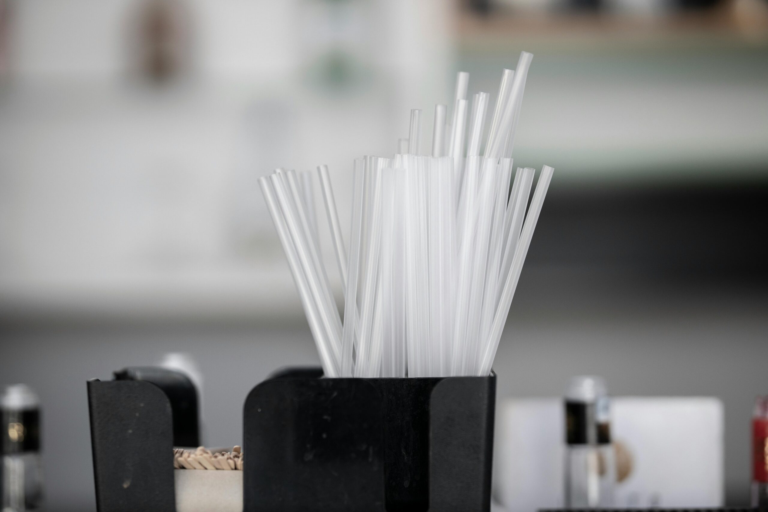 pexels photo 5377155 5377155 Close-up of plastic drinking straws in a black container, blurred background.