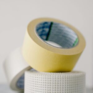 Various types of masking tapes on marble table near white wall at home