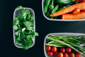 Organic vegetables displayed in plastic containers for a healthy diet.