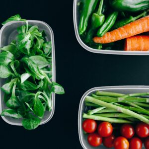Organic vegetables displayed in plastic containers for a healthy diet.