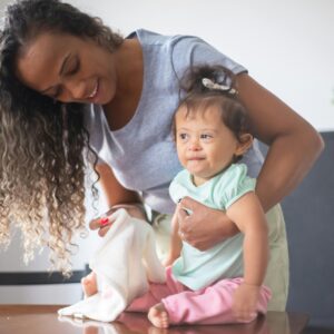 A happy mother and baby bonding in a cozy indoor setting, highlighting family love and care.