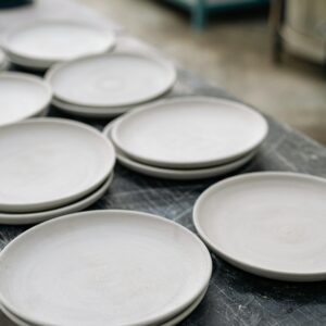 Close-up view of handcrafted ceramic plates on a table in a pottery workshop showcasing craftsmanship.