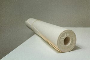 Close-up view of a rolled white paper on a desk, showcasing simplicity and texture.