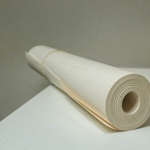 Close-up view of a rolled white paper on a desk, showcasing simplicity and texture.