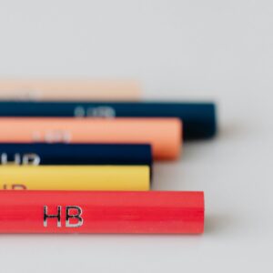 Close-up of vibrant HB pencils arranged on a white surface with selective focus.