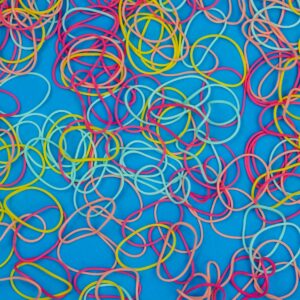 A vibrant collection of multicolored rubber bands scattered on a bright blue background.