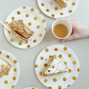 Top view of cake slices on polka dot plates and a cup of coffee. Perfect for dessert themes.