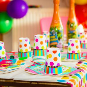 Colorful party table setup with polka dot cups and balloons, perfect for celebrations.