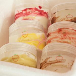 Colorful assortment of creamy ice cream in plastic tubs, perfect for a sweet chilled treat.