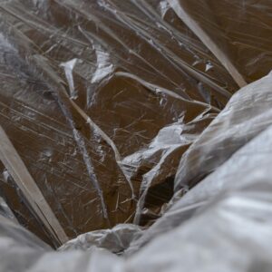 Close-up of transparent plastic sheeting over a wooden surface, revealing textures.
