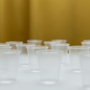 A collection of clear plastic cups arranged on a white table with a blurred background.