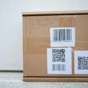 Close-up of a cardboard package with QR codes and a barcode, ideal for delivery and shipping concepts.
