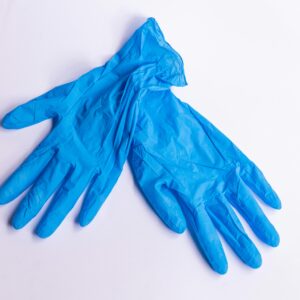 A pair of disposable blue latex gloves on a clean, white surface representing hygiene and safety.