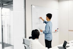 Business professional drawing graph during office presentation with colleague