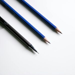 Close-up of a mechanical pencil and two wooden pencils on a white background.