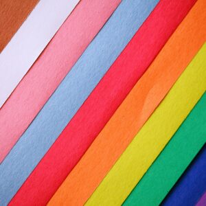Colorful diagonal arrangement of textured papers creating a vibrant rainbow pattern.