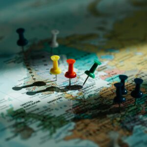 A close-up view of colorful push pins marking locations on a detailed world map.