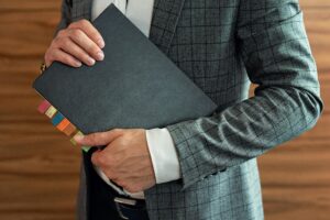 Businessperson in suit holding organized planner with tabs.