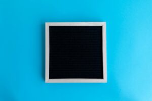 Empty blackboard with wooden frame on a vivid blue backdrop, perfect for copyspace.