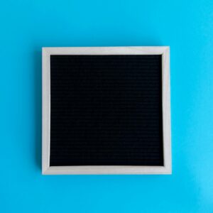 Empty blackboard with wooden frame on a vivid blue backdrop, perfect for copyspace.