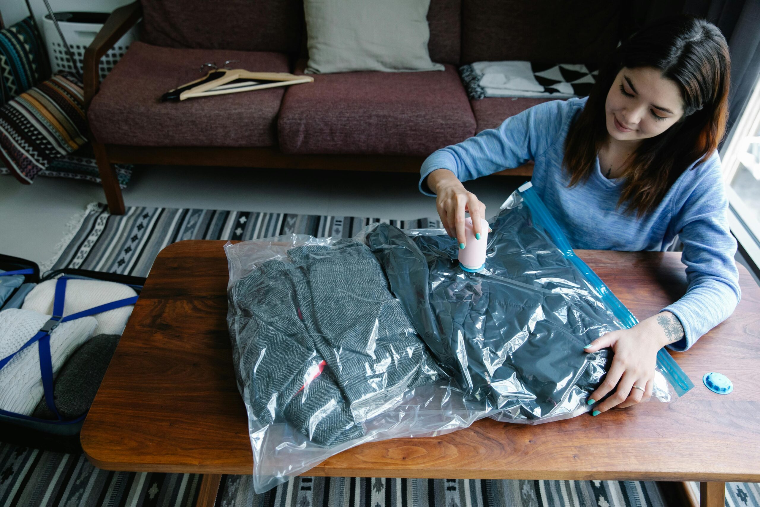 pexels photo 9186212 9186212 Woman sealing clothes in vacuum bags for efficient packing at home.