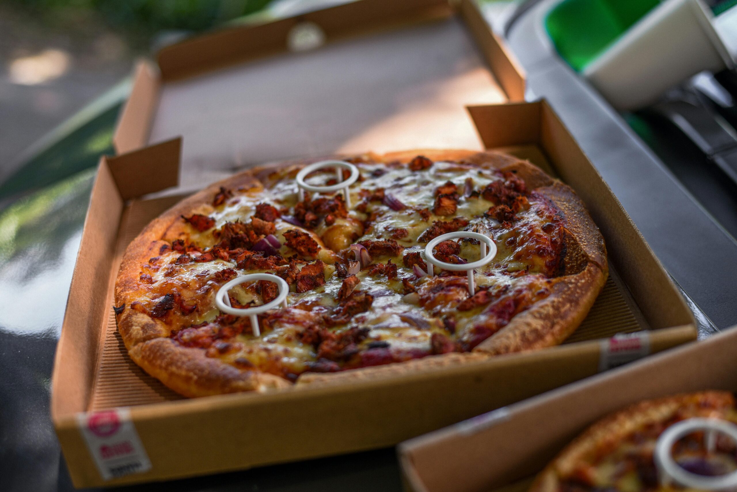 pexels photo 9692142 9692142 Close-up of a freshly baked pizza with toppings in a cardboard box, mouthwatering and ready to eat.